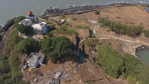 Drone tracking shot of lighthouse in a sea fortress by a rocky cliff Stock Footage 117333520