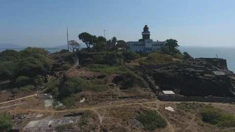 Drone tracking shot of lighthouse in a sea fortress by a rocky cliff Stock Footage 117347439