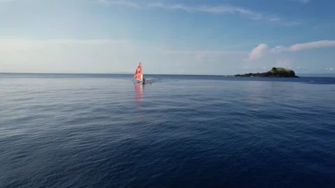 Drone Tracking Shot of Orange Outrigger Sailboat at Virgin Beach Stock Footage 337802251