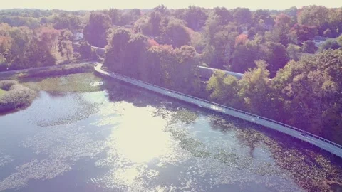 Drone Tracking shot - Train passing next to hiking trail with foliage &amp; lake Stock Footage 220104851