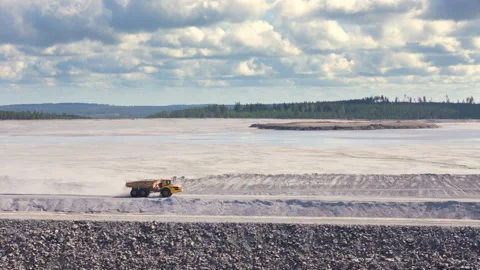 Drone tracking shot of yellow mining dump truck driving on dusty mine road Video stock 299665862
