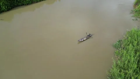 Drone Tracking a Small Boat on a Muddy River in Dak Lak, Vietnam Vidéo 343719908
