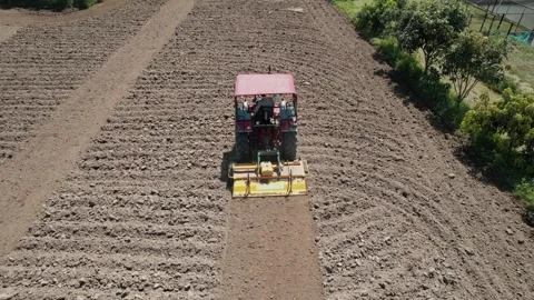 Drone tracking tractor from behind ploughing field 스톡 동영상 333271580