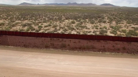 Drone tracking US border wall looking into Mexico Stock-Footage 63629268