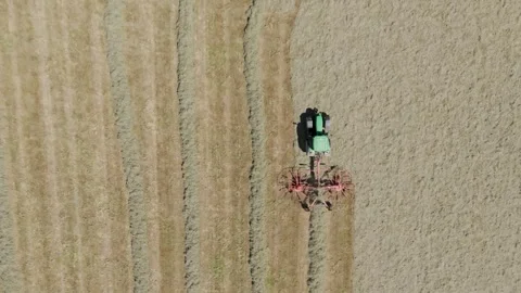 Drone tracking view of a green tractor pulling a large grass harvester Stock Footage 281766518
