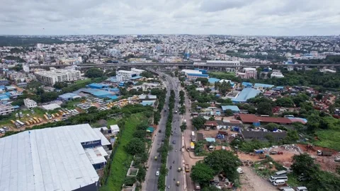 Drone tracking view of long ring road and metro train bridge amidst bangalo.. Stock-Footage 344879469