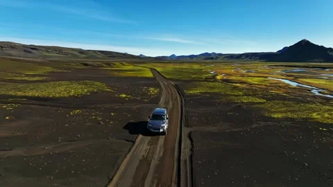 Drone tracks a 4x4 SUV on a winding dirt road through Iceland highlands—mossy Vídeo Stock 331304205
