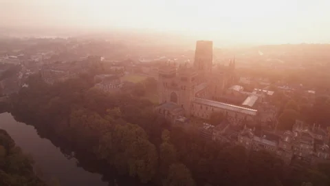 Drone tracks around the facade of Durham Cathedral over the River Wear at dawn Stock Footage 276419046