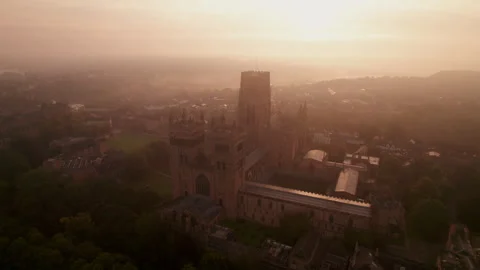 Drone tracks around the facade of Durham Cathedral at dawn Stock Footage 277577123