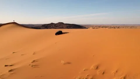 Drone tracks side-by-side UTV descending Erg Chebbi sand dune near Merzouga Stock Footage 339755518