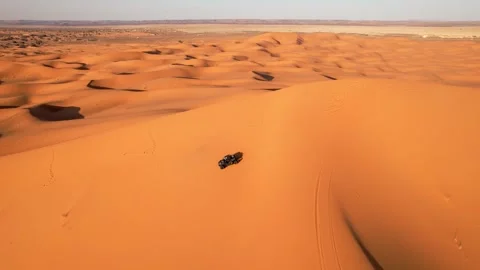 Drone tracks side-by-side UTV crossing Erg Chebbi dunes during guided Sahara Stock Footage 339755531