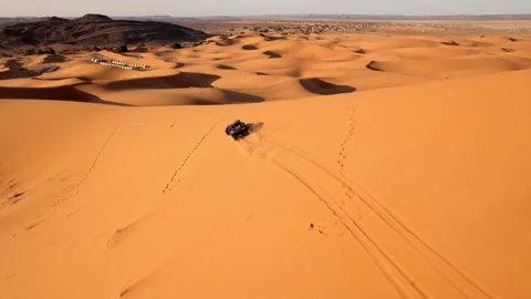 Drone tracks side-by-side UTV climbing Erg Chebbi dune near Merzouga Morocco Stock Footage 339755535