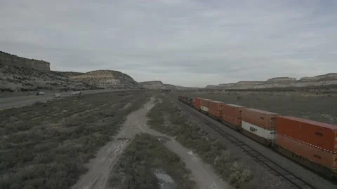 Drone tracks a train riding in a valley Stock Footage 161444859