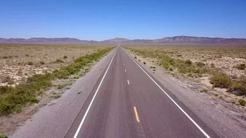 Drone traveling down long straight desert road Stock-Footage 92829882