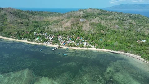 Drone turns and ascends above coastal village 库存影片 327470076