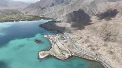 Drone turquoise alpine lake beside dry desert mountains in Xinjiang China Stock Footage 337754393