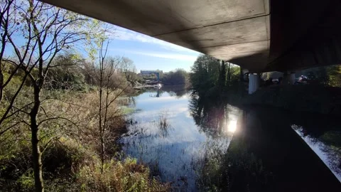 Drone: underside of road bridge crossing river Stock Footage 321544659