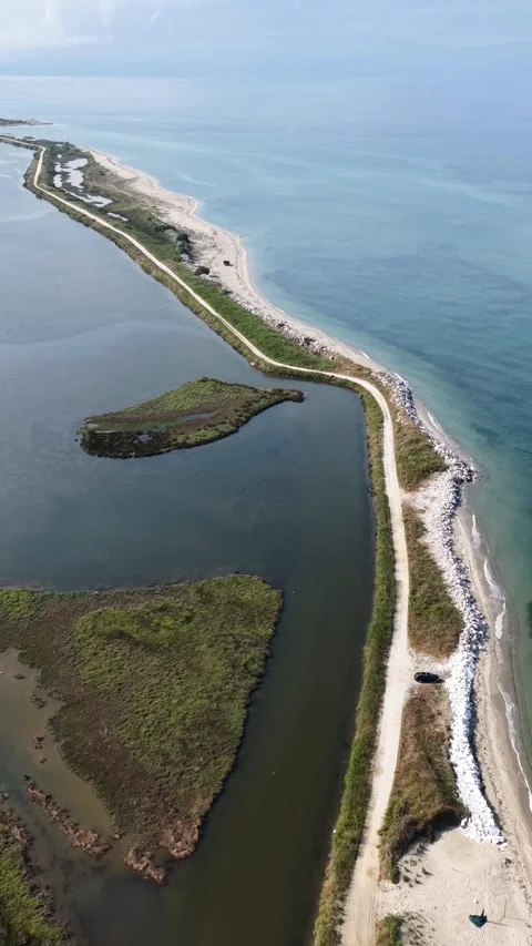 Drone Vertical Flyover of Narrow Sand Spit and Aegean Coastal Road in Greece Stock Footage 341386061