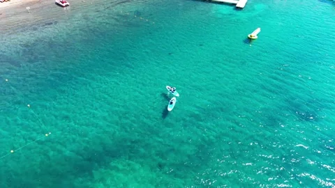 Drone Vertical Zooming Out Top Down View of People Paddleboarding on Turquo.. Stock Footage 339252273