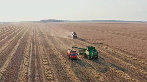 Drone Video - Backward Shot Of Unloading John Deere combine into a dump truck Stock Footage 172531307