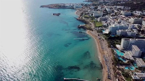 Drone video of beach with blue umbrellas near crystal sea Vidéo 211173003