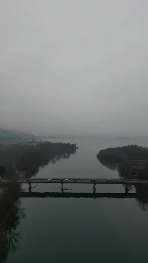 Drone video of bridge through north Italian river with auto vehicles driving Stock Footage 297606821