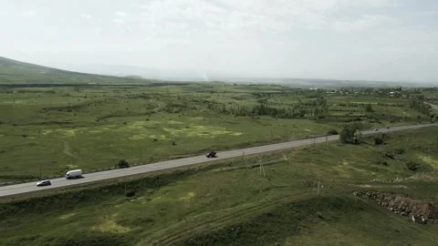 Drone video. A busy highway with moving cars surrounded by fields and mountains. Stock Footage 252010293