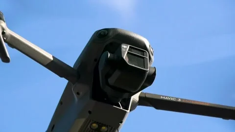 A drone with a video camera flies in the sky against the background of clouds Stock Footage 255149405