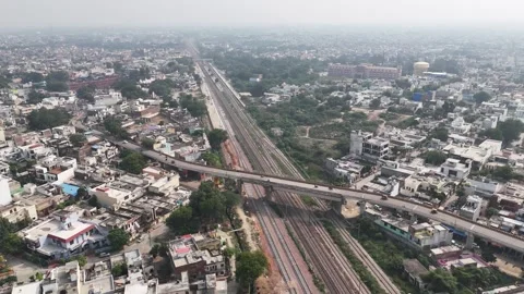 Drone video capturing parallel rail lines, an urban overpass, and tightly Stockbeeldmateriaal 328735541