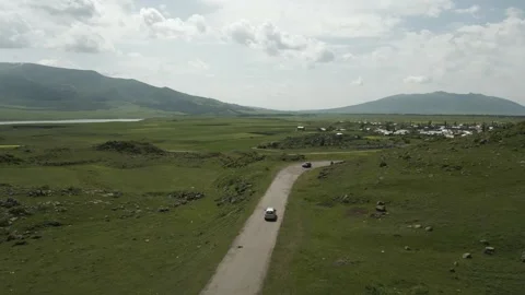 Drone video. Car driving on an old road, hills, village, mountains. Stock Footage 252014318