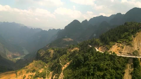 Drone video of a car driving on a road on a mountain with a stunning valley view Video stock 313798448
