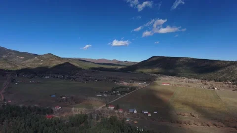 Drone video of cloud shadows passing over a mountain valley Stock Footage 143168547