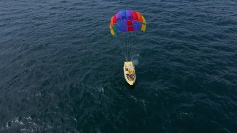 Drone video of a colorful parasail being towed by a speedboat over the ocean Stock Footage 281983553
