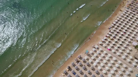 Drone video of a crowded beach with rows of umbrellas and sunbathers, set Stock Footage 281965793