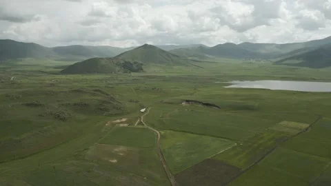 Drone video. Fields between green stony hills. Lake, villages, mountains. Stock Footage 252017045