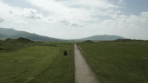 Drone video. Fly over the road behind the car between green hills. Armenia. Video stock 252012082
