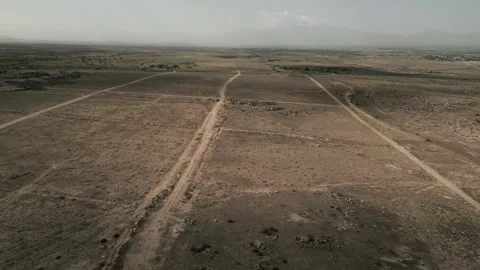 Drone video. Flying over deserted rocky terrain. Highway, buildings, mountains. Stock Footage 252001917