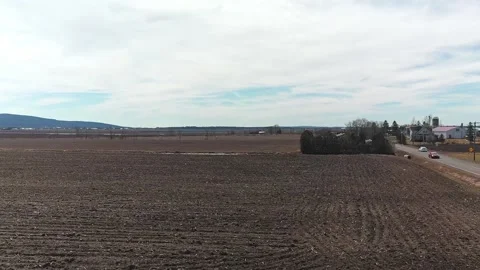 Drone video flying over an empty field in spring with a cloudy sky Stock-Footage 164799006