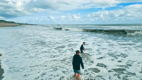 Drone video footage shot on a sunset sea sand beach siblings - two boys swi.. Stock Footage 236426053