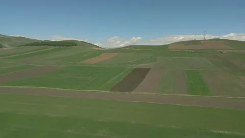 Drone video. Green fields, crossed by country roads and power lines, village. Stock Footage 252927369