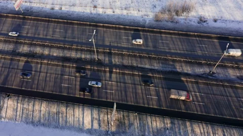 Drone Video - Highway with tree shadows, dirty snow and moving cars Stock Footage 173026403