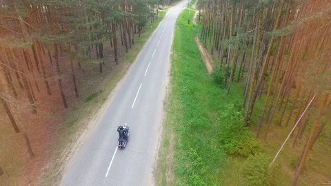 Drone video of a motorcyclist driving away. Stock Footage