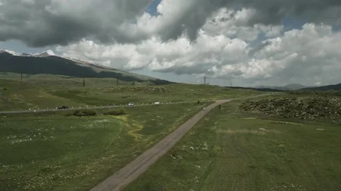 Drone video. Old road and highway, green hills, power lines, snowy mountains. Stock Footage 252012610