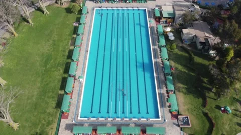 Drone video of an olympic sized swimming pool surrounded by green grass Vidéo 219020593