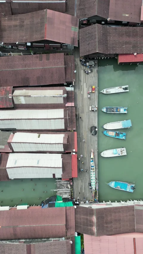 Drone video over a dock with boats and houses with sheet metal roofing Stock Footage 246134555