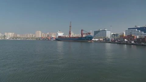 Drone video in a port showing a container cargo ship, containers on the quayside Stock Footage 175586702