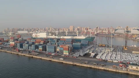 Drone video in a port showing a container cargo ship, containers on the quayside Stock Footage 175648426