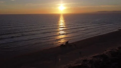 Drone video of Strong orange sunset with fisherman catching fish in Portugal Stock Footage 194456226