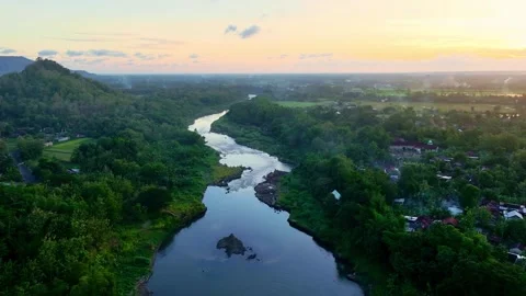 Drone video of sunset river through tropical hills Stock Footage 336315392