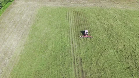 Drone video of a tractor mixing cut grass for faster drying Stock Footage 312069993